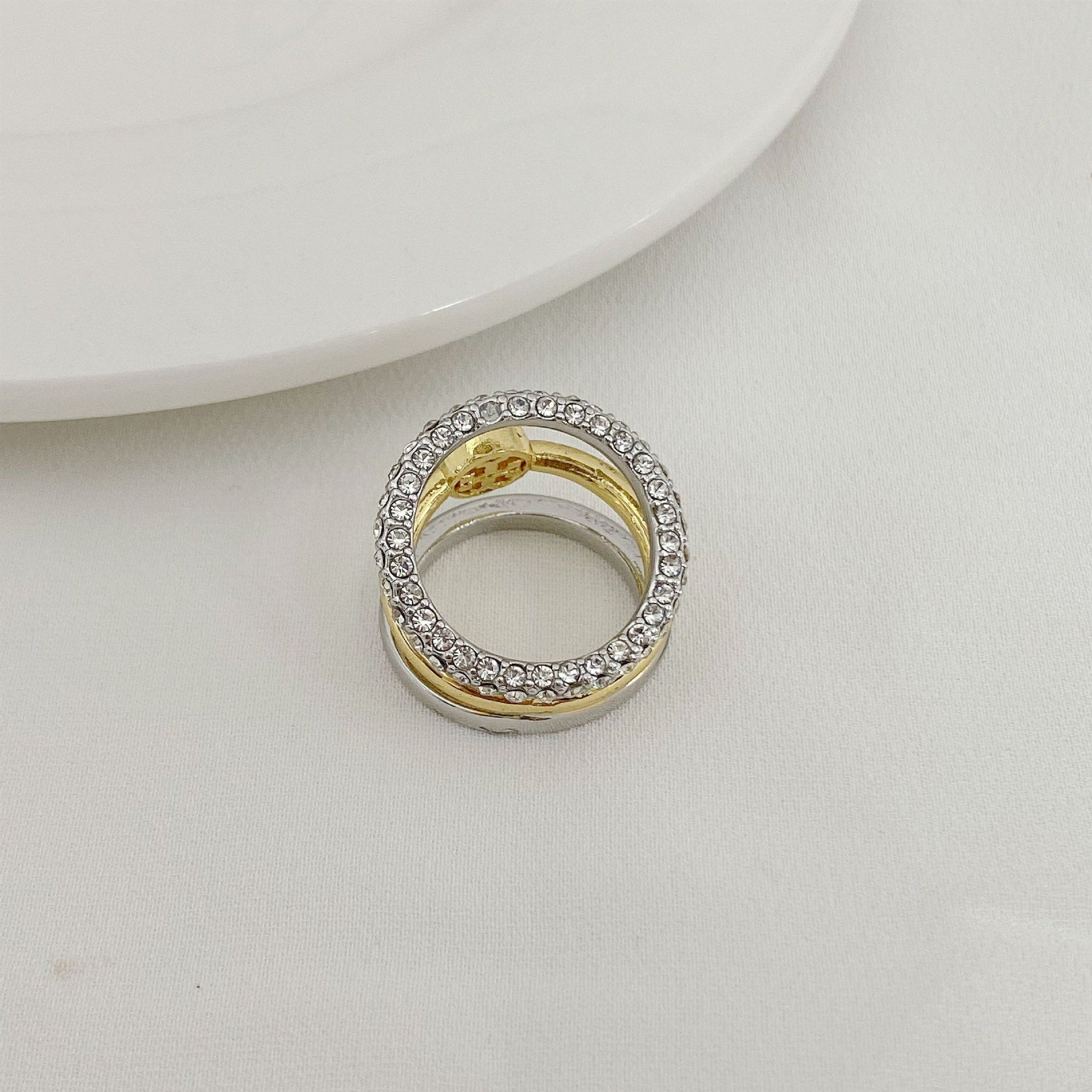 Two-tone three-band ring with silver pavé halo and gold inner band