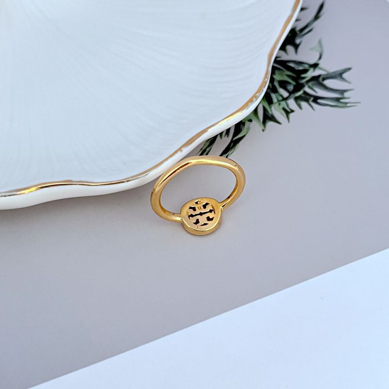 Gold-tone round logo ring, openwork emblem with pavé stones; slim band