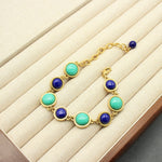 Gold-tone round stone bracelet with turquoise and dark blue beads on display