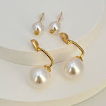 Gold-tone pearl earrings with large drop pearls and small stud pearls