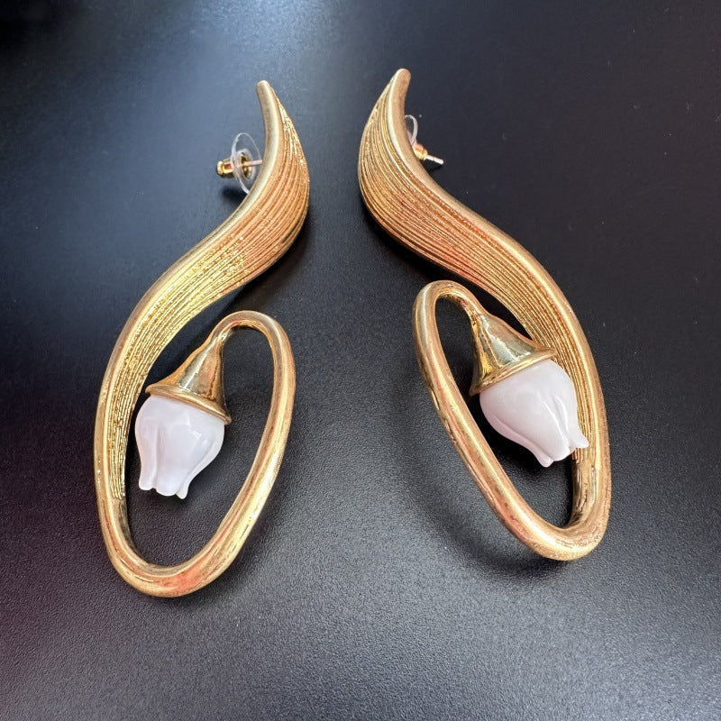 Gold-tone clip-on earrings: arched oval hoops with white bell flower charms