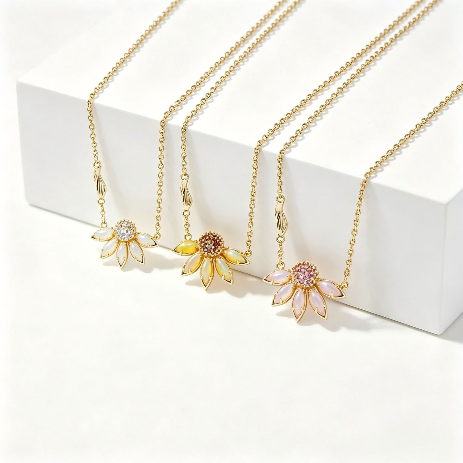 Gold-tone flower pendant necklaces with rhinestone centers in white, yellow, and pink petals