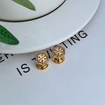 Hexagonal metal stud earrings with openwork diamond pattern, gold color