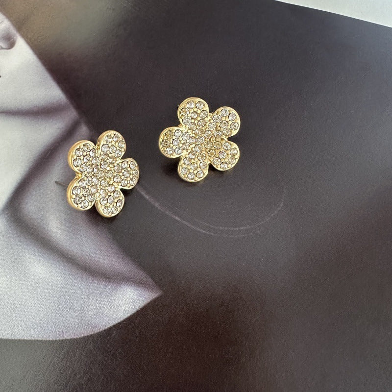 Gold diamond floral stud earrings with clear stones