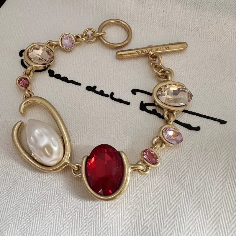 O-ring crystal pearl bracelet, gold tone with red oval center stone, pink crystals, pearl
