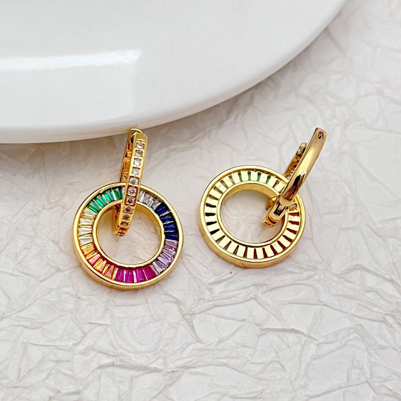 Two gold-tone zircon donut pendant earrings with multicolor ring border and stud backs