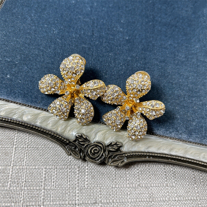 Five-petal diamond flower earrings in gold tone with clear pavé stones