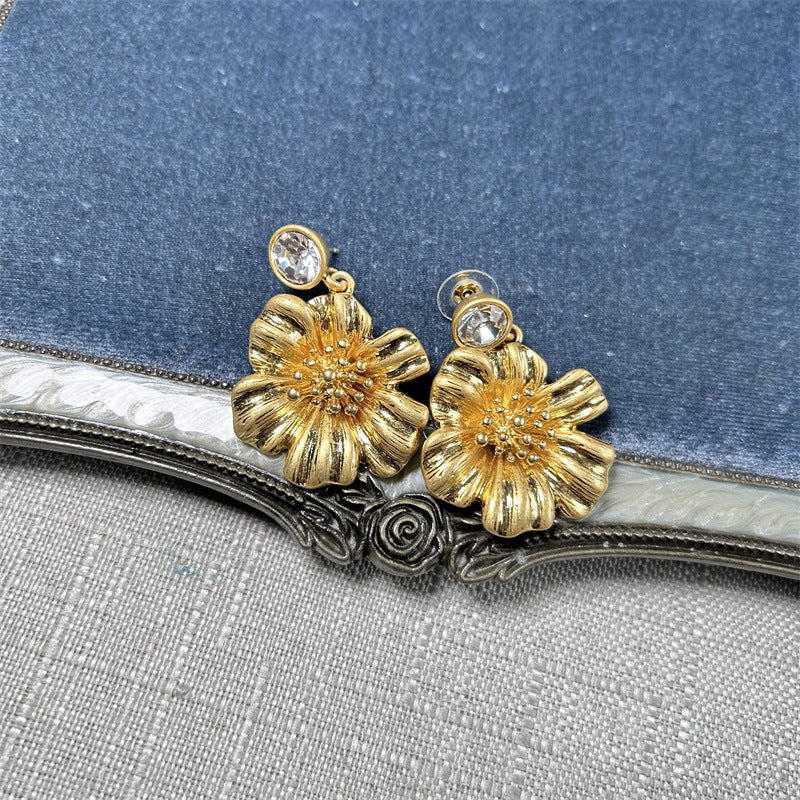Gold-tone cherry blossom earrings with round crystal studs and textured floral petals