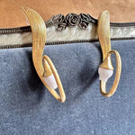 Gold-tone clip-on earrings with oval hoops and white bell flower drops