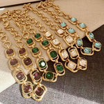 Gold link crystal necklace with assorted faceted stones, including green and clear