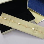 Gold-tone clover bracelet with white agate flower links and four-leaf motif chain