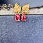 Red crystal drop earrings with gold-tone textured caps
