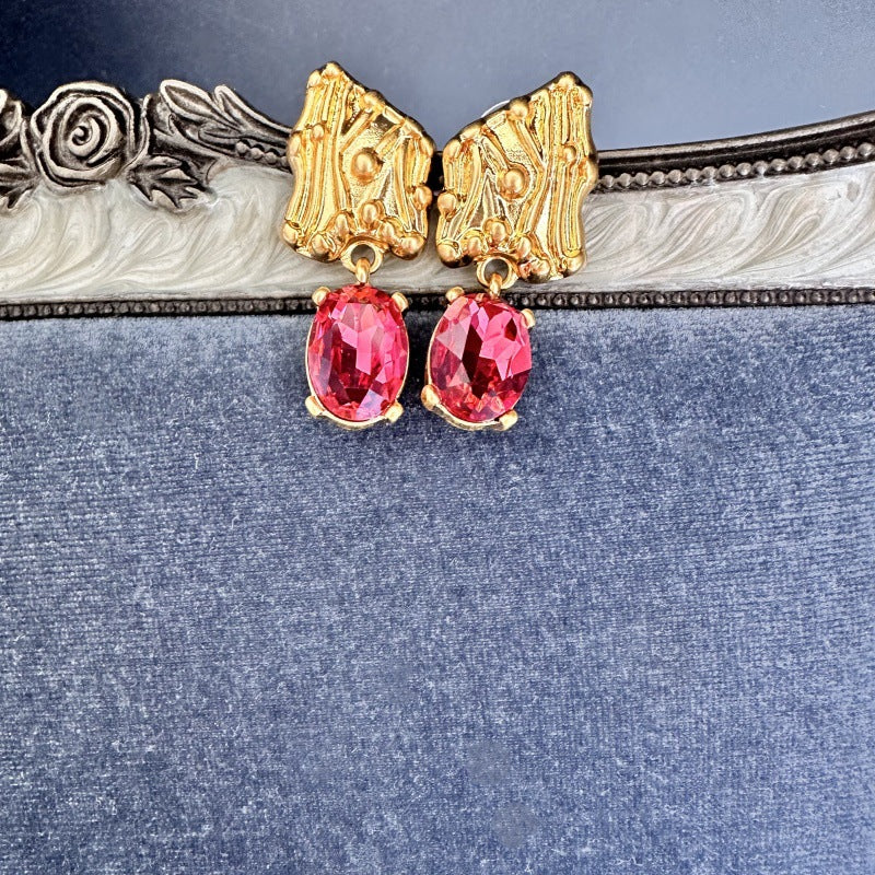 Red crystal drop earrings with gold-tone textured caps