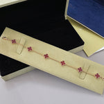 Goldfarbenes Kleeblatt-Armband mit mehreren Anhängern in Rot