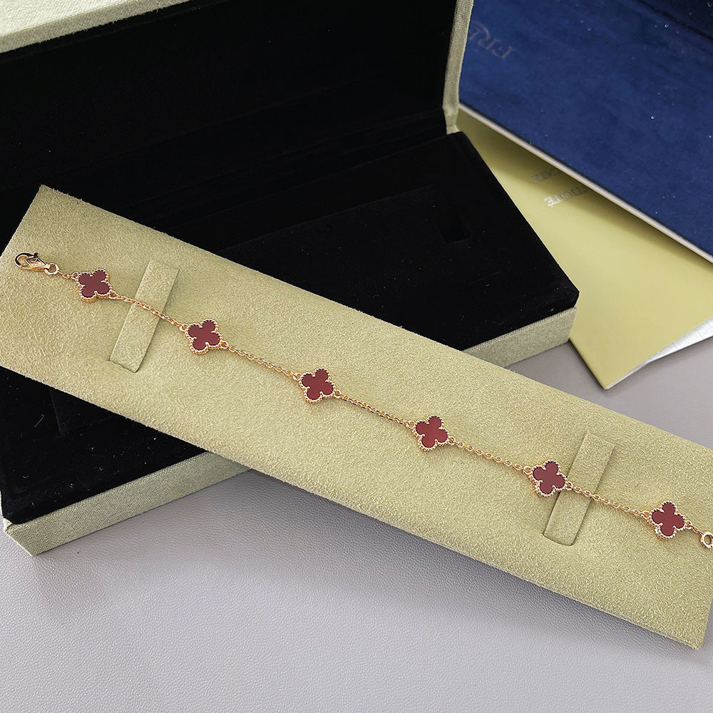 Goldfarbenes Kleeblatt-Armband mit mehreren Anhängern in Rot