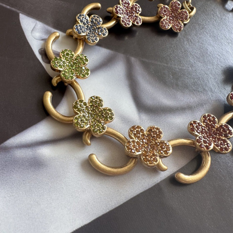 Gold-tone floral O-ring necklace with green crystal flower charms and gold O-links