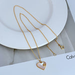 Gold-tone heart-shaped shell pendant necklace with small links and round clasp