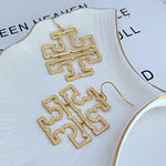 Gold minimalist logo drop earrings with layered geometric cutout sections and hooks