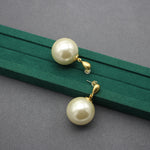 Pair of gold faux-pearl drop earrings with large ivory spheres and loop detail