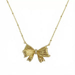 Gold bow pendant necklace with small round crystal in center