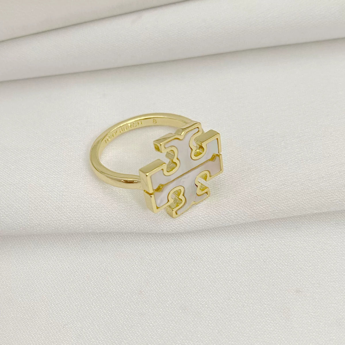 Gold openwork logo ring with geometric centerpiece and slim band