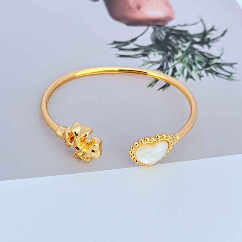 Gold open bangle with heart charm and mother-of-pearl inlay, two-sided design