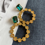 Large round floral zircon earrings with emerald green stones and goldtone flower halo