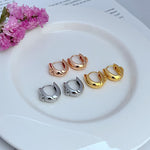 Petite U-shaped metal hoop earrings in gold, rose gold, and silver tones