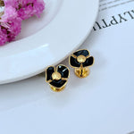 Enamel Camellia stud earrings, black flower with gold-tone center