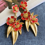 Red enamel floral drop earrings with large red flowers and gold-tone teardrop spikes