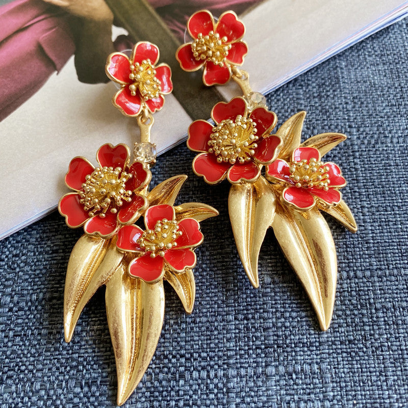 Red enamel floral drop earrings with large red flowers and gold-tone teardrop spikes