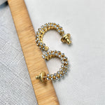 Gold-tone cubic zirconia C-hoop earrings with yellow and clear stones; angled view