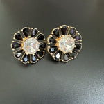 Sunburst flower stud earrings with black teardrop stones and clear round center, gold-tone