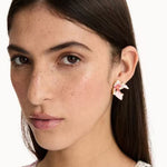 Floral enamel earrings, pink and white petals, worn on ear