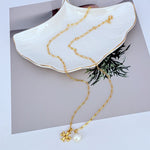 Gold-tone Tory Burch pendant necklace with small pearl and logo flower charm