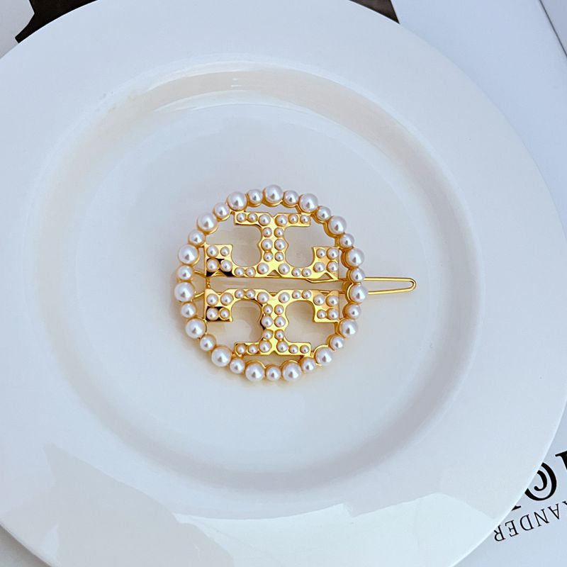 Gold metal hair clip, circular openwork logo with pearl bead border and flat pin