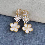 Enamel plum blossom drop earrings, white flowers with pearl centers on gold-toned drops