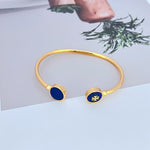 Round enamel shell open metal bangle with blue round discs and gold-tone clasp.