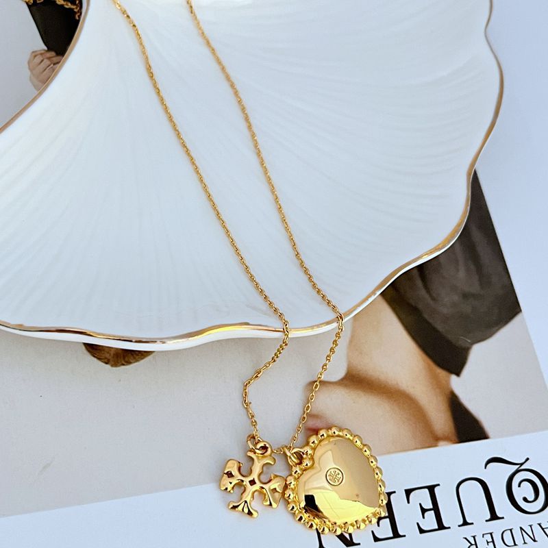 Gold heart pendant necklace with mother-of-pearl shell inlay and floral rosette charm
