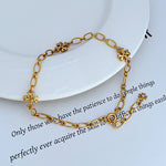 Interlocking logo chain bracelet with gold-tone clover charm accents and lobster clasp