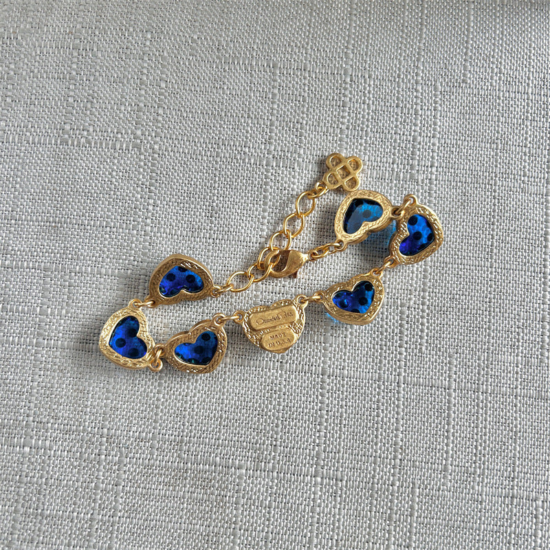 Blue matte heart bracelet close-up, gold-tone chain with heart charms