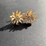 Enamel flower earrings with gold-tone white petals and clear center stones, stud style