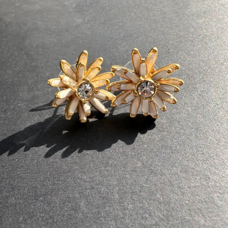 Enamel flower earrings with gold-tone white petals and clear center stones, stud style
