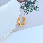 Gold metal ring with openwork logo band, visible edge profile