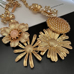 Gold-tone enamel daisy flower necklace with large textured daisy and crystal center