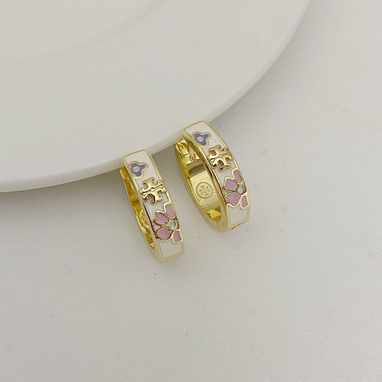 Enamel flower hoop earrings in gold with purple and pink flower accents