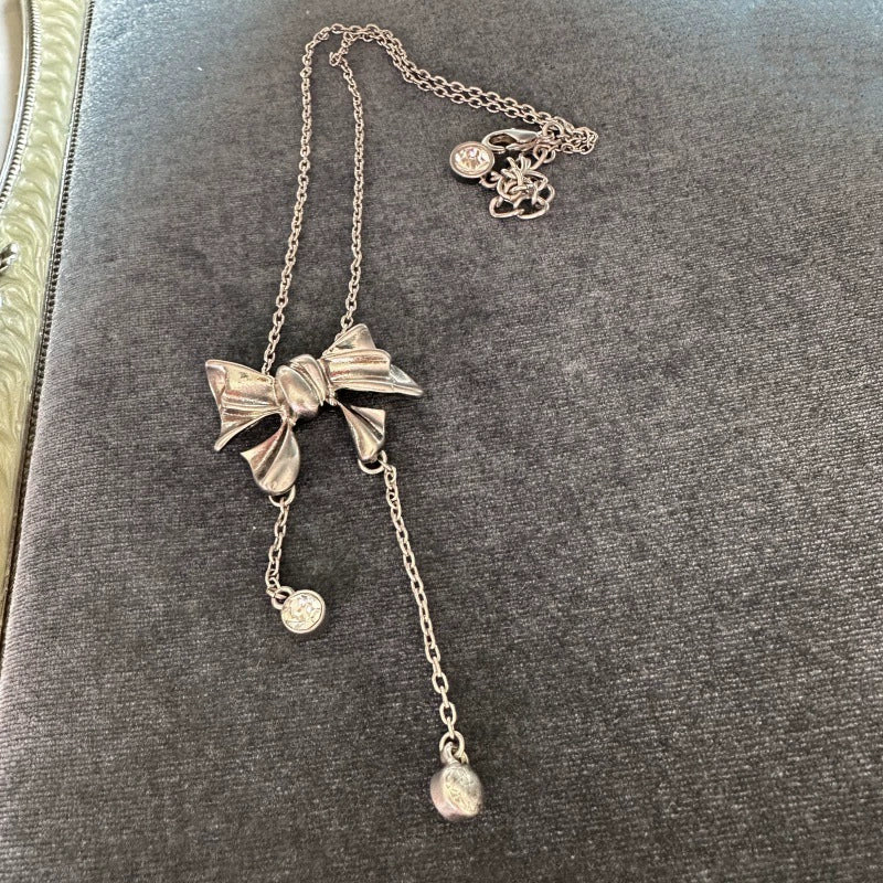 Silver-tone bow crystal tassel necklace with round crystal dangles and linked chain