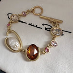 O-ring crystal pearl bracelet, gold tone with amber oval center stone and pink crystal links