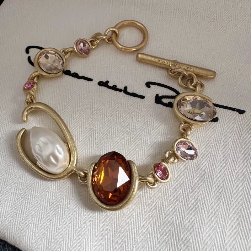 O-ring crystal pearl bracelet, gold tone with amber oval center stone and pink crystal links