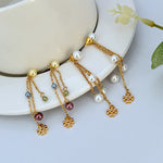 Pearl chain tassel earrings: gold-tone, white pearls, colored bead drops, logo charms
